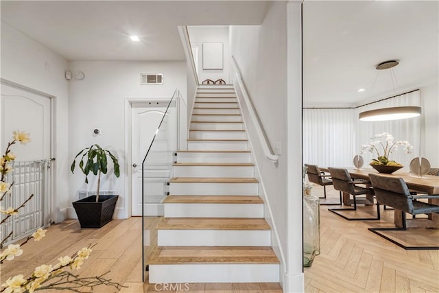 stairway featuring parquet floors