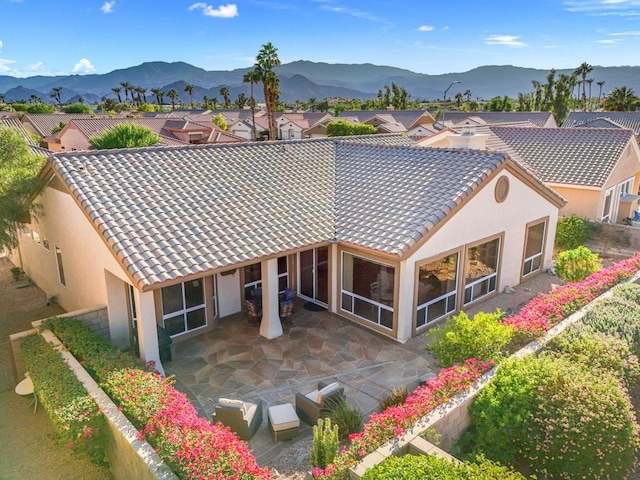 back of house featuring a mountain view and a patio