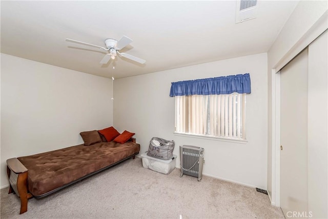 bedroom featuring ceiling fan, light carpet, and a closet