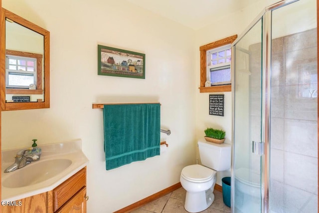 bathroom featuring tile patterned floors, vanity, toilet, and a shower with door