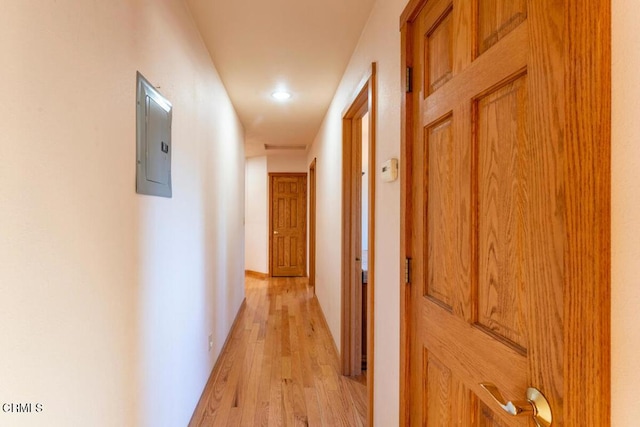 corridor featuring electric panel and light hardwood / wood-style flooring