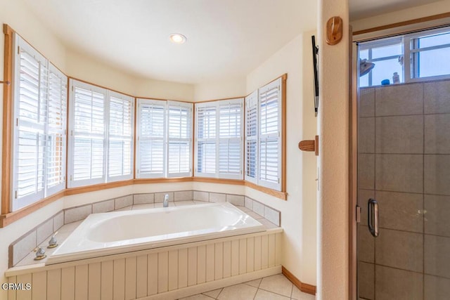 bathroom with tile patterned floors, a stall shower, baseboards, and a garden tub
