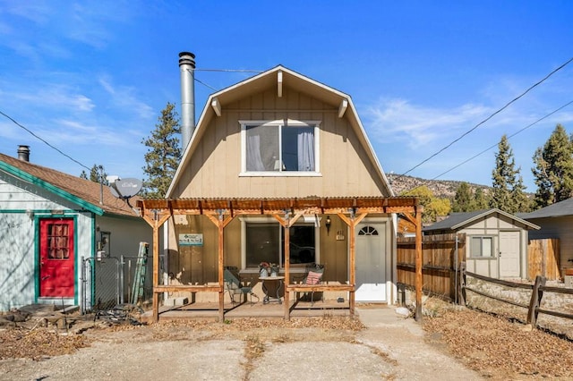 rear view of house with a storage unit and a patio area