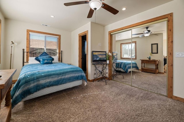 carpeted bedroom featuring multiple windows, ceiling fan, and a closet