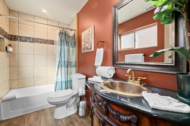 full bathroom featuring vanity, hardwood / wood-style flooring, toilet, and shower / bath combo with shower curtain