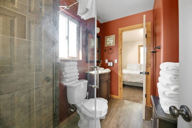 bathroom with a tile shower, toilet, vanity, and hardwood / wood-style flooring