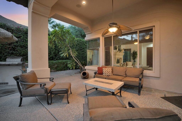 patio terrace at dusk featuring an outdoor hangout area and ceiling fan