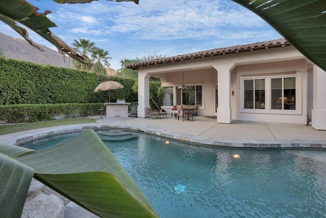 view of swimming pool with a bar, a patio, and ceiling fan