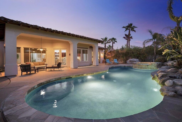 pool at dusk featuring an in ground hot tub, french doors, an outdoor living space, ceiling fan, and a patio area