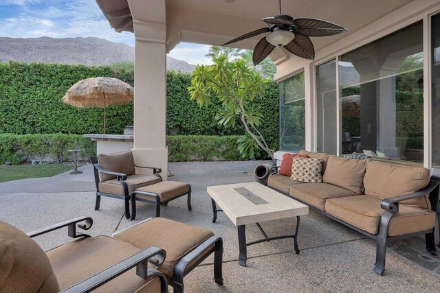 view of patio featuring a mountain view, ceiling fan, and an outdoor living space