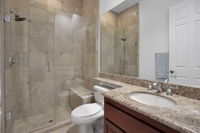 bathroom with vanity, a shower with shower door, and toilet