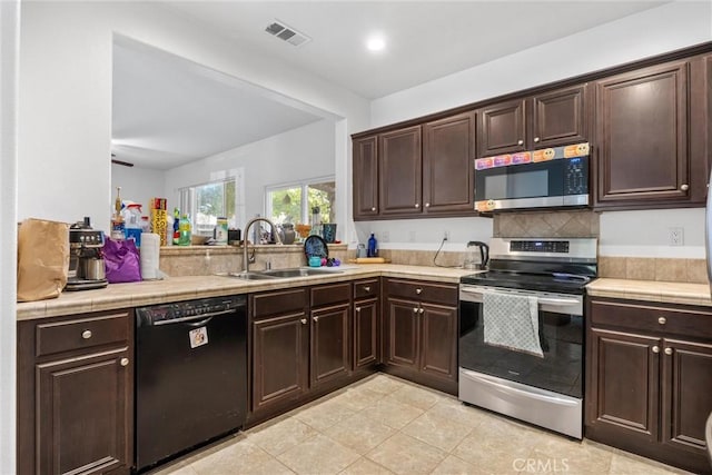 kitchen with dark brown cabinetry, sink, and stainless steel appliances