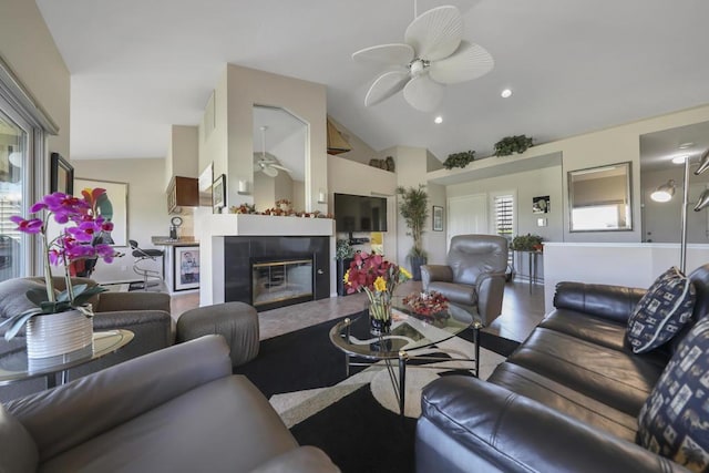 living room featuring plenty of natural light, ceiling fan, a fireplace, and vaulted ceiling