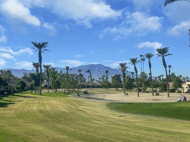 view of property's community featuring a lawn and a mountain view