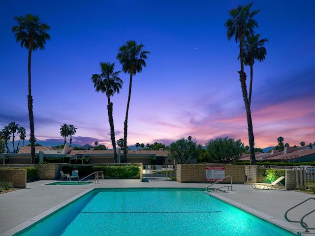 pool at dusk featuring a patio area