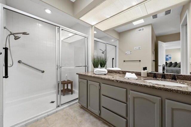 bathroom featuring tile patterned flooring, vanity, and walk in shower