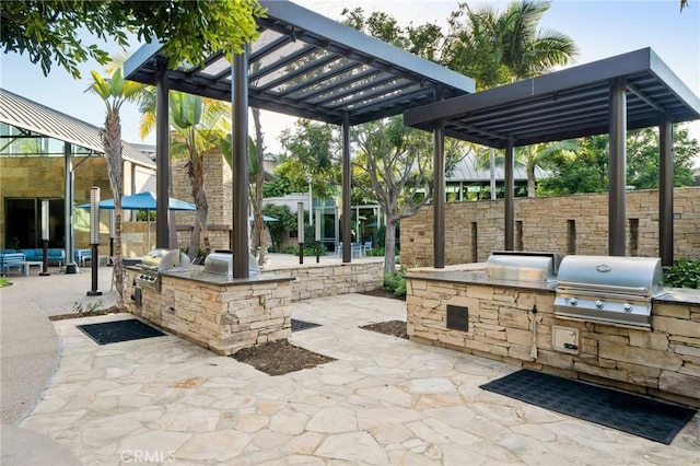 view of patio featuring an outdoor kitchen, a grill, and a pergola