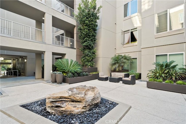 view of community featuring an outdoor hangout area and a patio