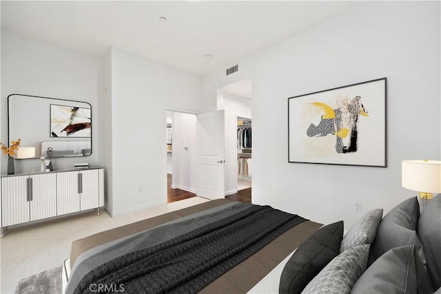 bedroom with a spacious closet, a closet, and dark wood-type flooring