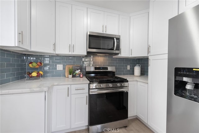 kitchen featuring white cabinetry, stainless steel appliances, and tasteful backsplash