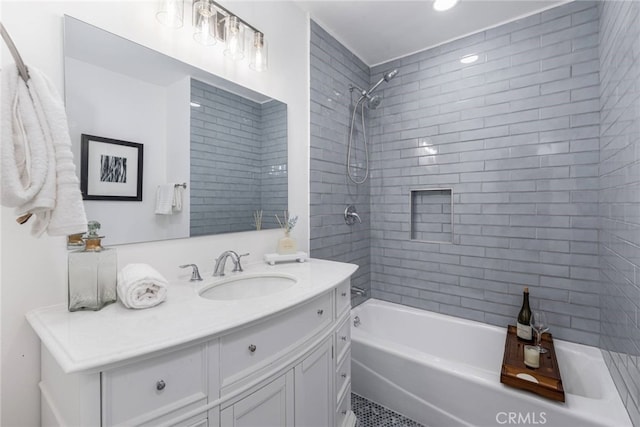 bathroom with tiled shower / bath combo and vanity