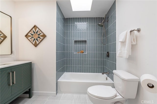 full bathroom featuring toilet, vanity, tiled shower / bath, tile patterned floors, and a skylight