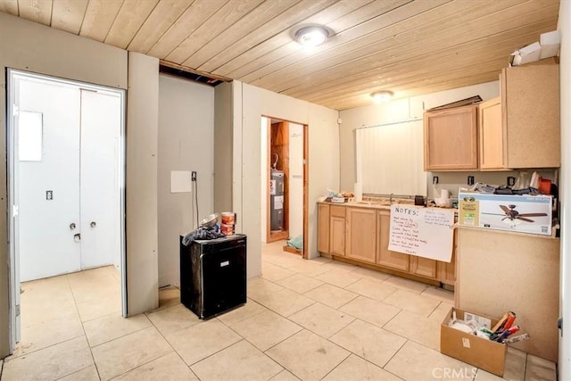 kitchen with light brown cabinetry, water heater, wooden ceiling, and light tile patterned flooring