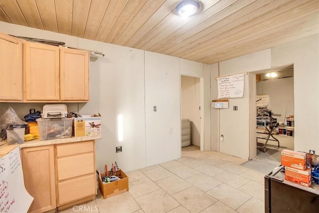 kitchen with light brown cabinets, light tile patterned floors, and wood ceiling