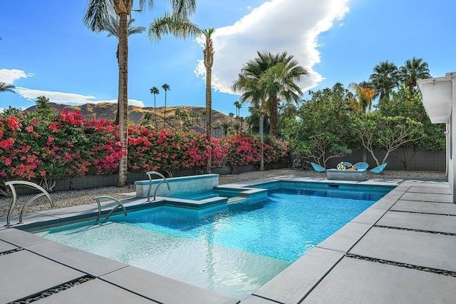 view of pool with a mountain view, an in ground hot tub, and a patio area