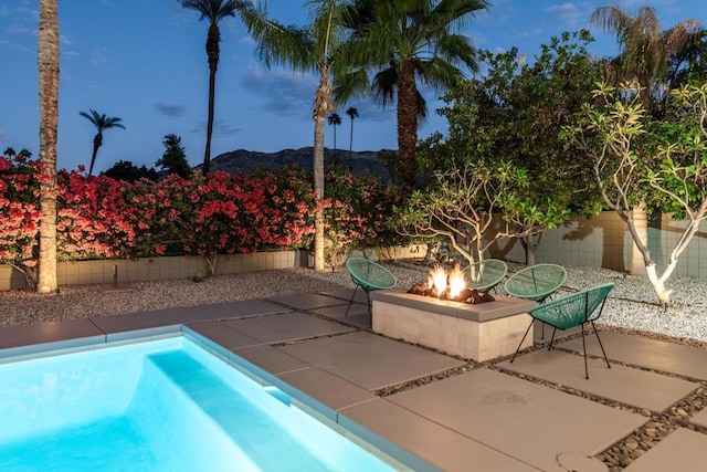 view of pool with a mountain view, a patio, and an outdoor fire pit