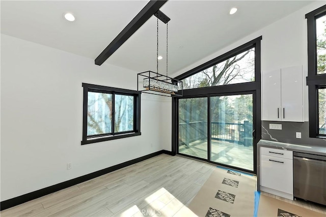 unfurnished dining area with a notable chandelier, beamed ceiling, and light wood-type flooring