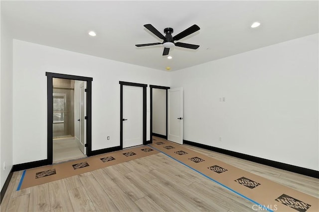 unfurnished bedroom featuring ensuite bath, ceiling fan, and light wood-type flooring