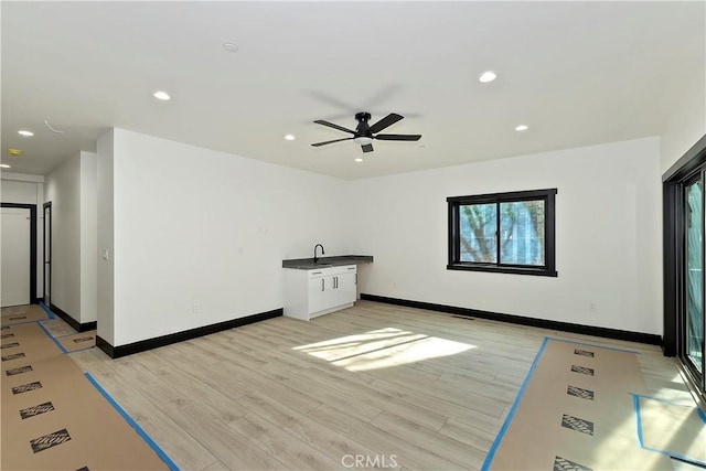 unfurnished living room with ceiling fan and light wood-type flooring