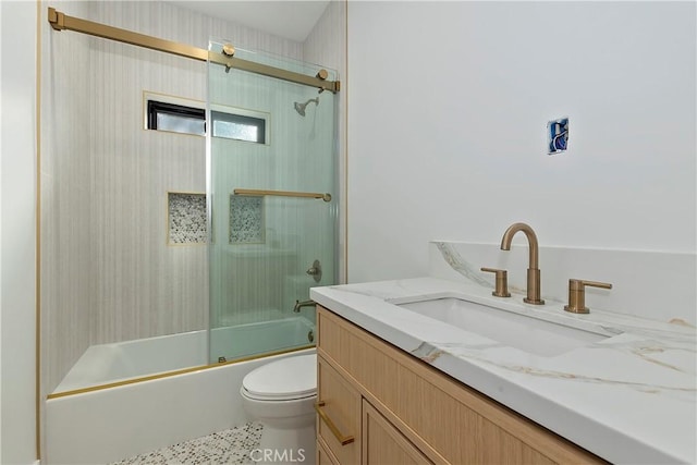 full bathroom featuring combined bath / shower with glass door, vanity, and toilet