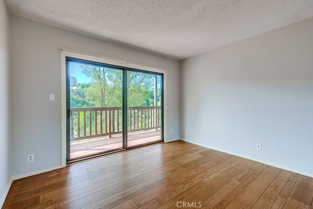 unfurnished room with hardwood / wood-style floors and a textured ceiling