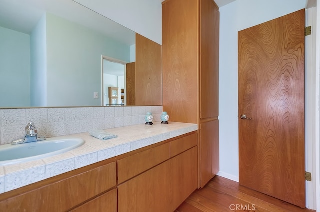 bathroom featuring decorative backsplash, vanity, and wood-type flooring