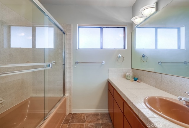 bathroom featuring tile patterned flooring, vanity, a healthy amount of sunlight, and enclosed tub / shower combo