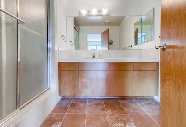 bathroom with tile patterned floors, vanity, and an enclosed shower