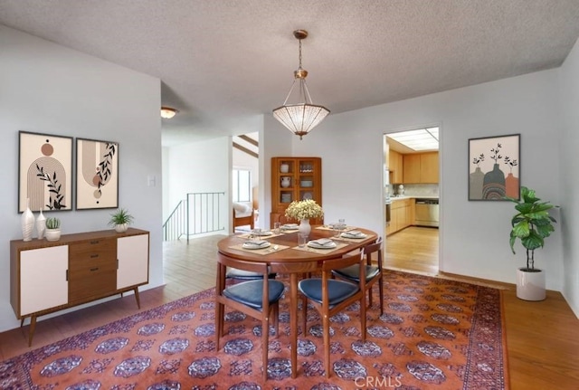 dining area with hardwood / wood-style floors and a textured ceiling