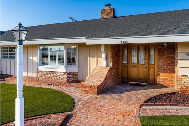 property entrance with covered porch and a lawn