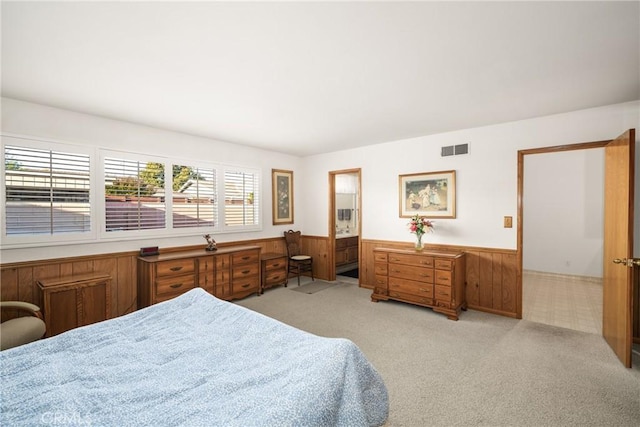 bedroom featuring light colored carpet and wood walls