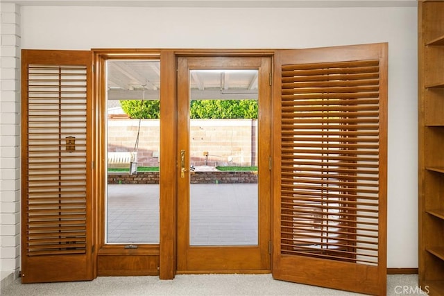 doorway to outside featuring light carpet and french doors