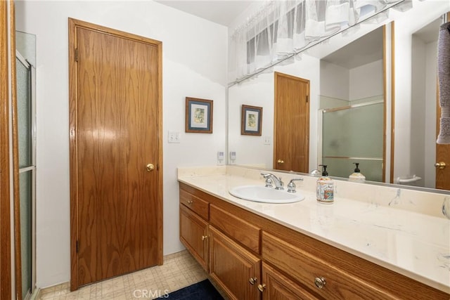 bathroom with vanity and a shower with door