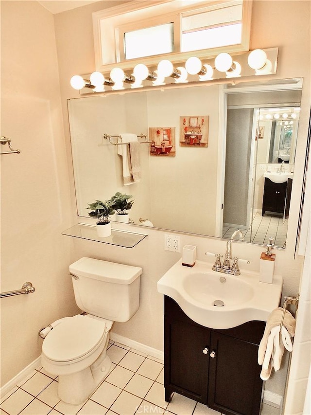 bathroom featuring tile patterned flooring, vanity, toilet, and baseboards