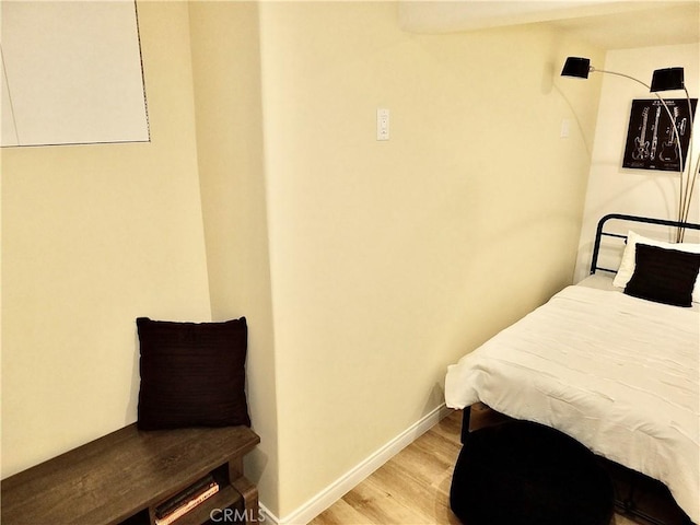 bedroom featuring baseboards and light wood finished floors