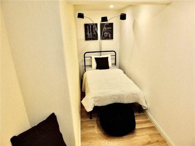 bedroom featuring baseboards and wood finished floors