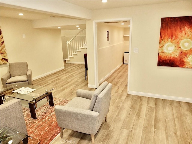 living room with stairway, light wood-style flooring, baseboards, and recessed lighting