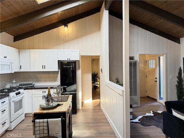 kitchen featuring hardwood / wood-style floors, vaulted ceiling with beams, white cabinets, and white appliances