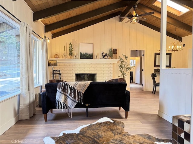 living room with wooden ceiling, ceiling fan with notable chandelier, vaulted ceiling with beams, a fireplace, and wood-type flooring