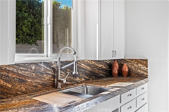 kitchen featuring backsplash, white cabinetry, and sink